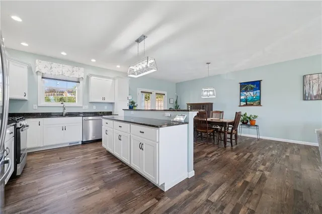 a large kitchen with lots of counter space and chairs