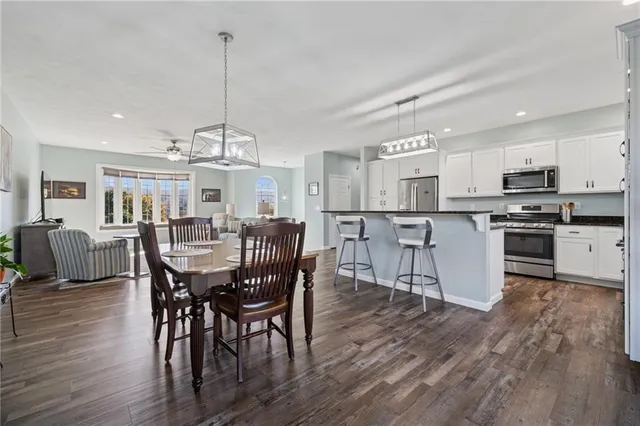 a view of a dining room and livingroom with furniture wooden floor a chandelier