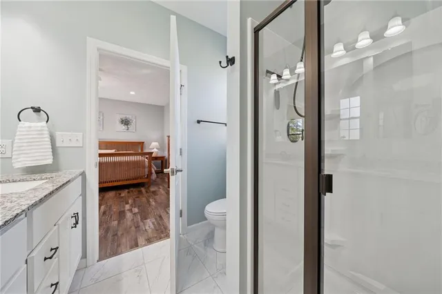 a en suite bathroom with a granite countertop sink and a mirror