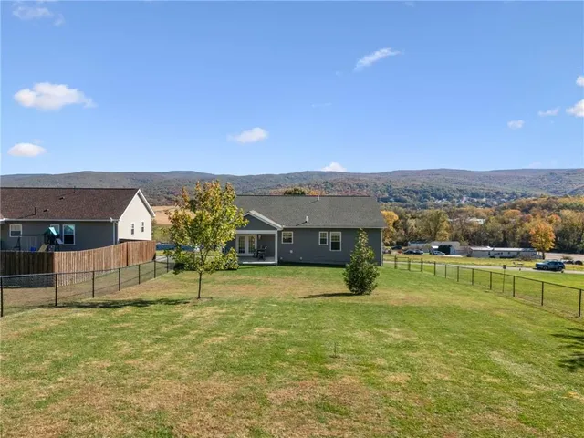a view of a big house with a big yard and large tree