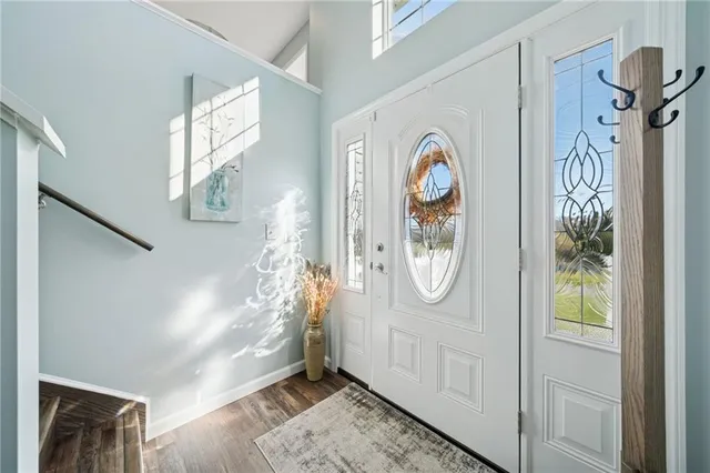 a view of an entryway with wooden floor and mirror