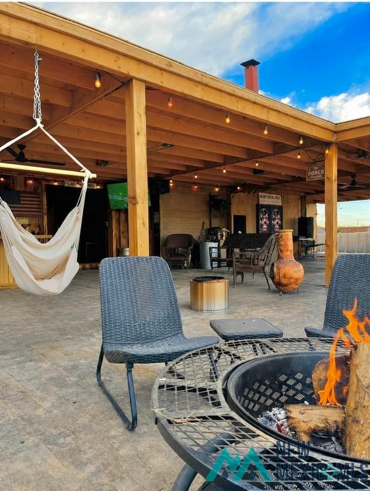5404 Sioux Road Carlsbad, NM 88220 - Photo 64 of 100 Spacious outdoor living area featuring a covered patio, exposed wood beam ceiling, decorative string lighting, and stamped concrete flooring