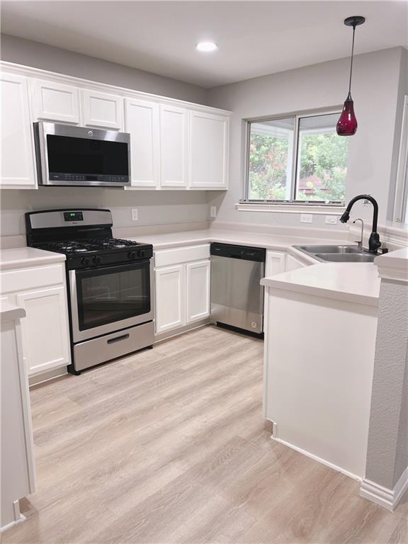 21415 Derby Day Avenue Pflugerville, TX 78660 - Photo 6 of 9 a kitchen with kitchen island a stove a sink and a microwave