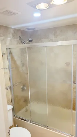 a bathroom with a glass shower door