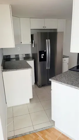 a kitchen with a sink a refrigerator and cabinets