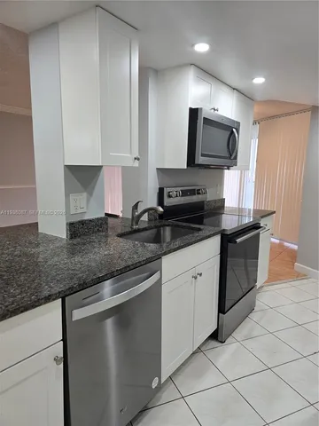 a kitchen with stainless steel appliances granite countertop a sink and a stove