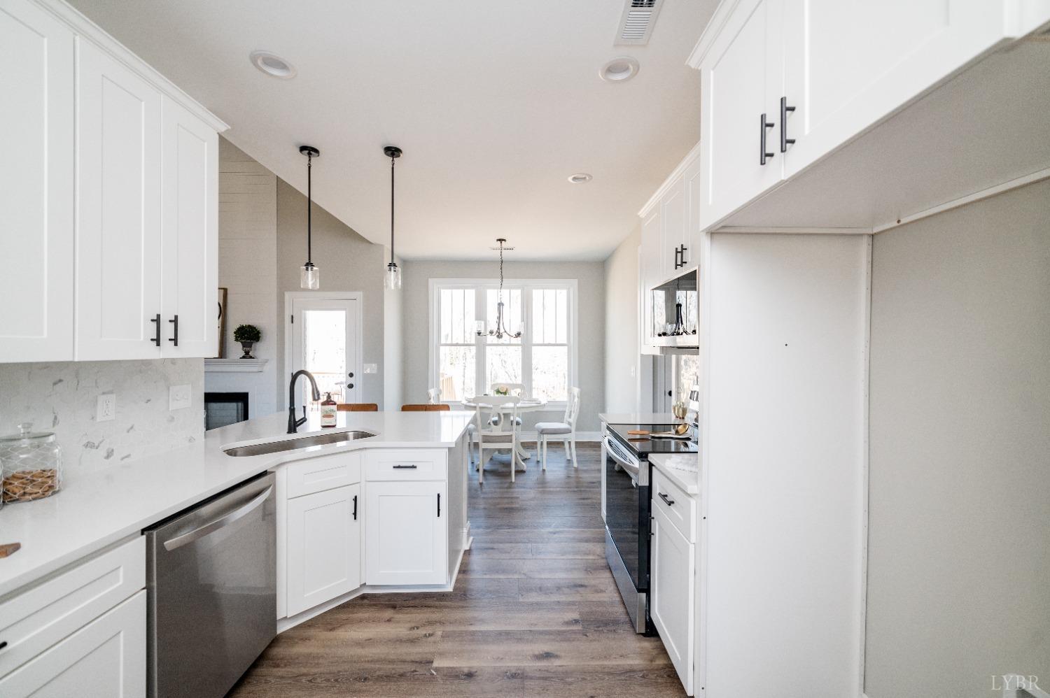 506 Bridge Tree Court Evington, VA 24550 - Photo 15 of 60 a kitchen with a sink dishwasher stove and white cabinets with wooden floor