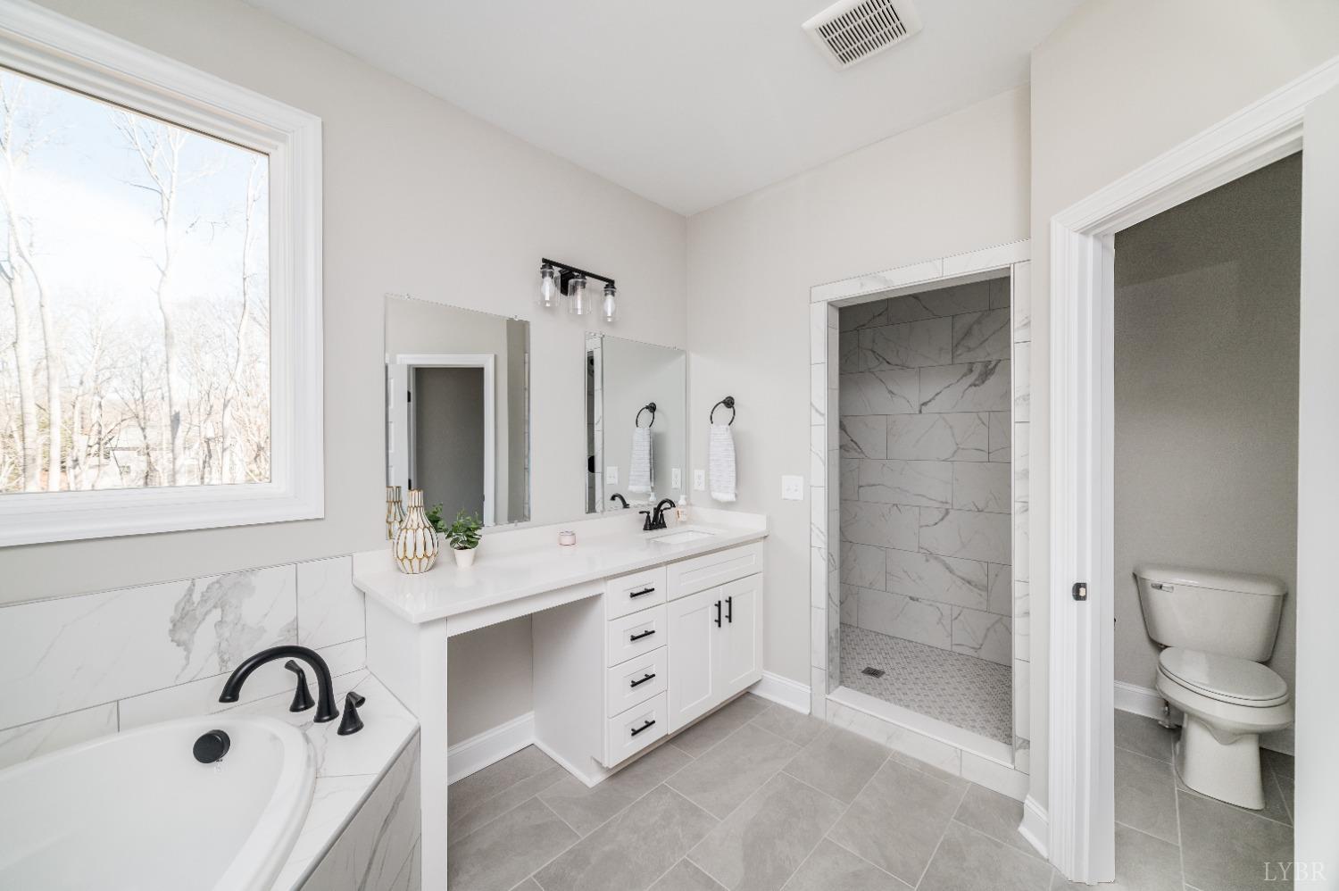 506 Bridge Tree Court Evington, VA 24550 - Photo 27 of 60 a spacious bathroom with a double vanity sink toilet mirror and bathtub