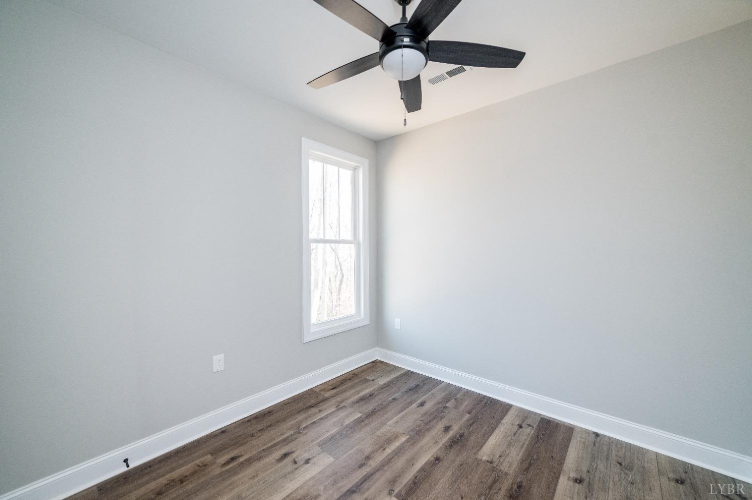506 Bridge Tree Court Evington, VA 24550 - Photo 33 of 60 an empty room with wooden floor fan and windows