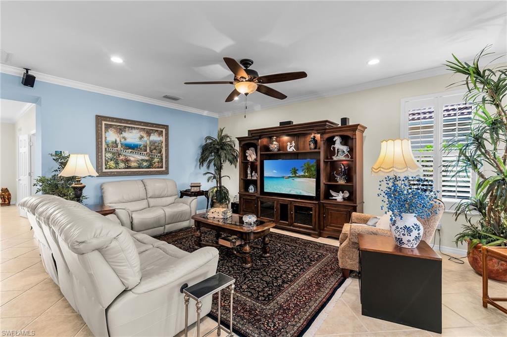 8595 Palermo Court Naples, FL 34114 - Photo 16 of 49 a living room with furniture a ceiling fan and a flat screen tv