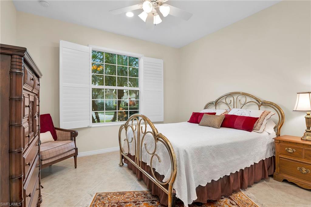 8595 Palermo Court Naples, FL 34114 - Photo 22 of 49 a bedroom with a bed a couch and a dresser next to a window