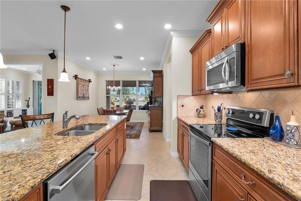 8595 Palermo Court Naples, FL 34114 - Photo 6 of 49 a kitchen with granite countertop stainless steel appliances a sink a stove top oven a counter space and cabinets