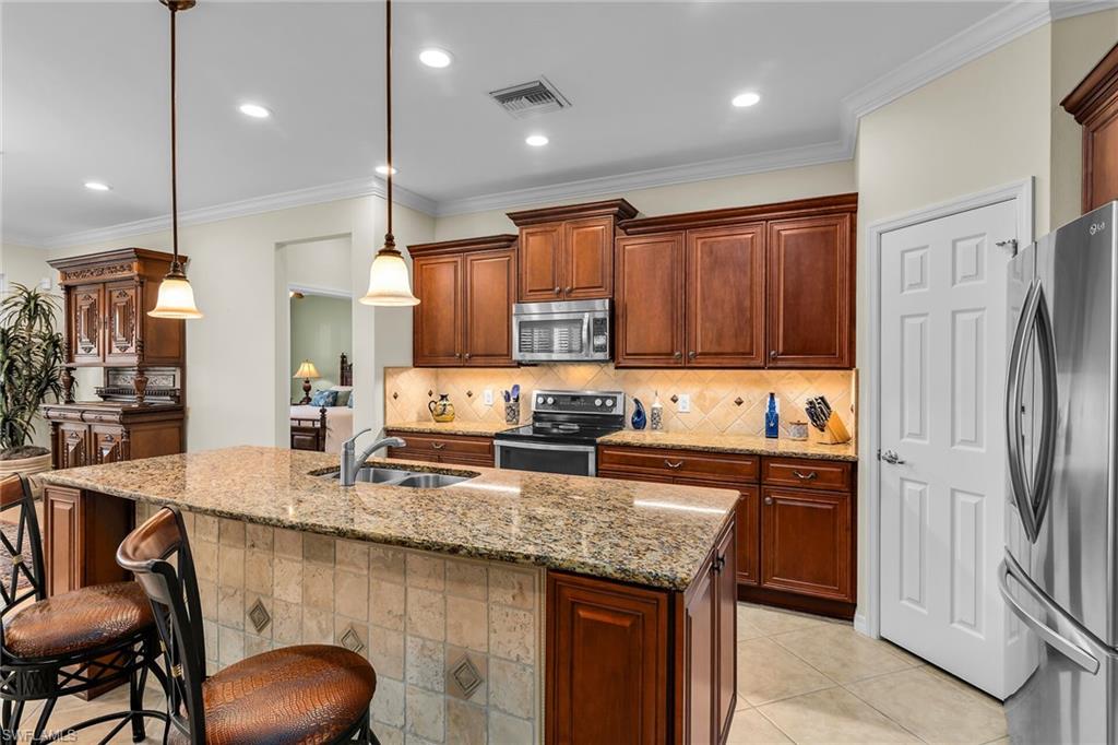 8595 Palermo Court Naples, FL 34114 - Photo 7 of 49 a kitchen with stainless steel appliances granite countertop a sink refrigerator and cabinets