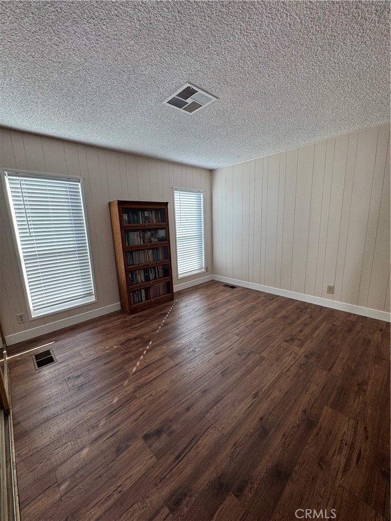 8651 Foothill Boulevard, Unit 157 Rancho Cucamonga, CA 91730 - Photo 11 of 19 an empty room with wooden floor and windows