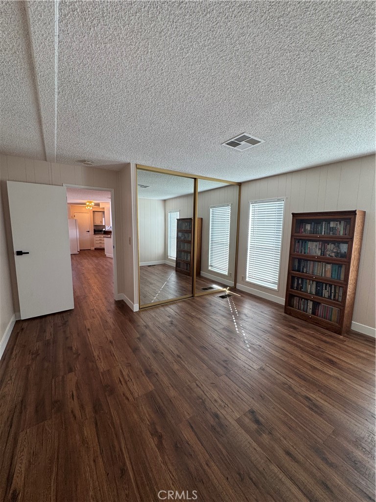 8651 Foothill Boulevard, Unit 157 Rancho Cucamonga, CA 91730 - Photo 12 of 19 an empty room with wooden floor and closet