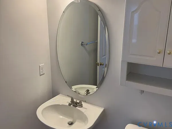 a bathroom with a sink mirror and toilet