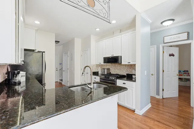 a kitchen with stainless steel appliances granite countertop a refrigerator a stove and a sink