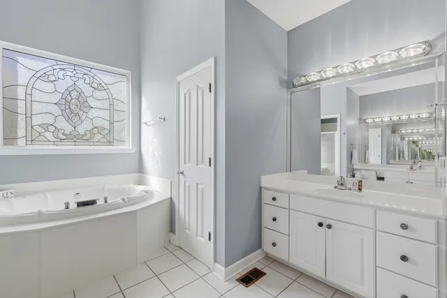 a spacious bathroom with a double vanity sink mirror and bathtub