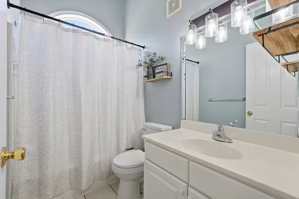 a bathroom with a sink a toilet and shower curtain