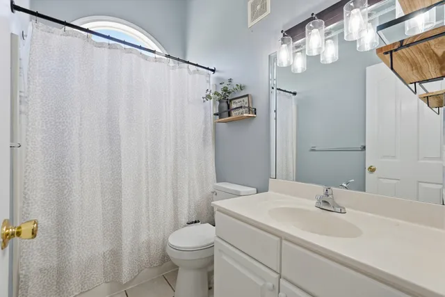 a bathroom with a sink a toilet and shower curtain