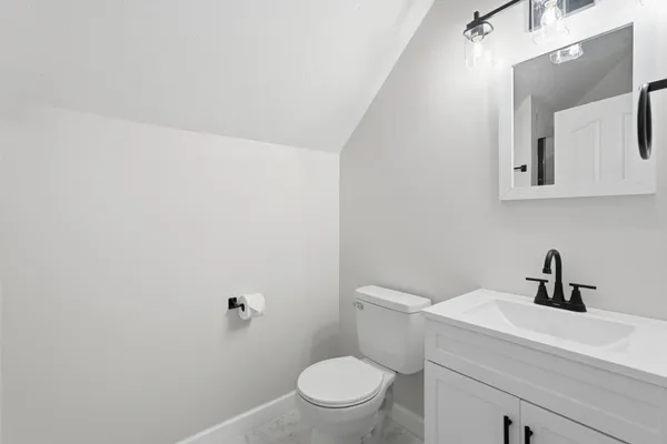 a bathroom with a toilet a sink and mirror