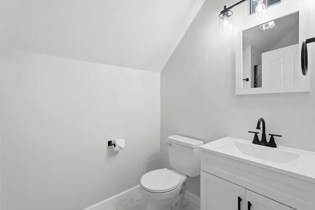 a bathroom with a toilet a sink and mirror