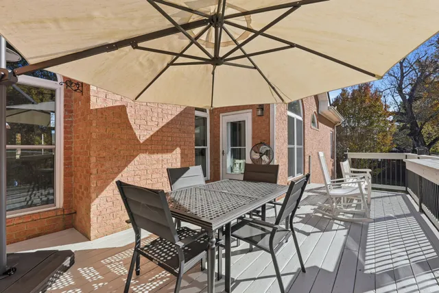 a view of a patio with a table and chairs under an umbrella