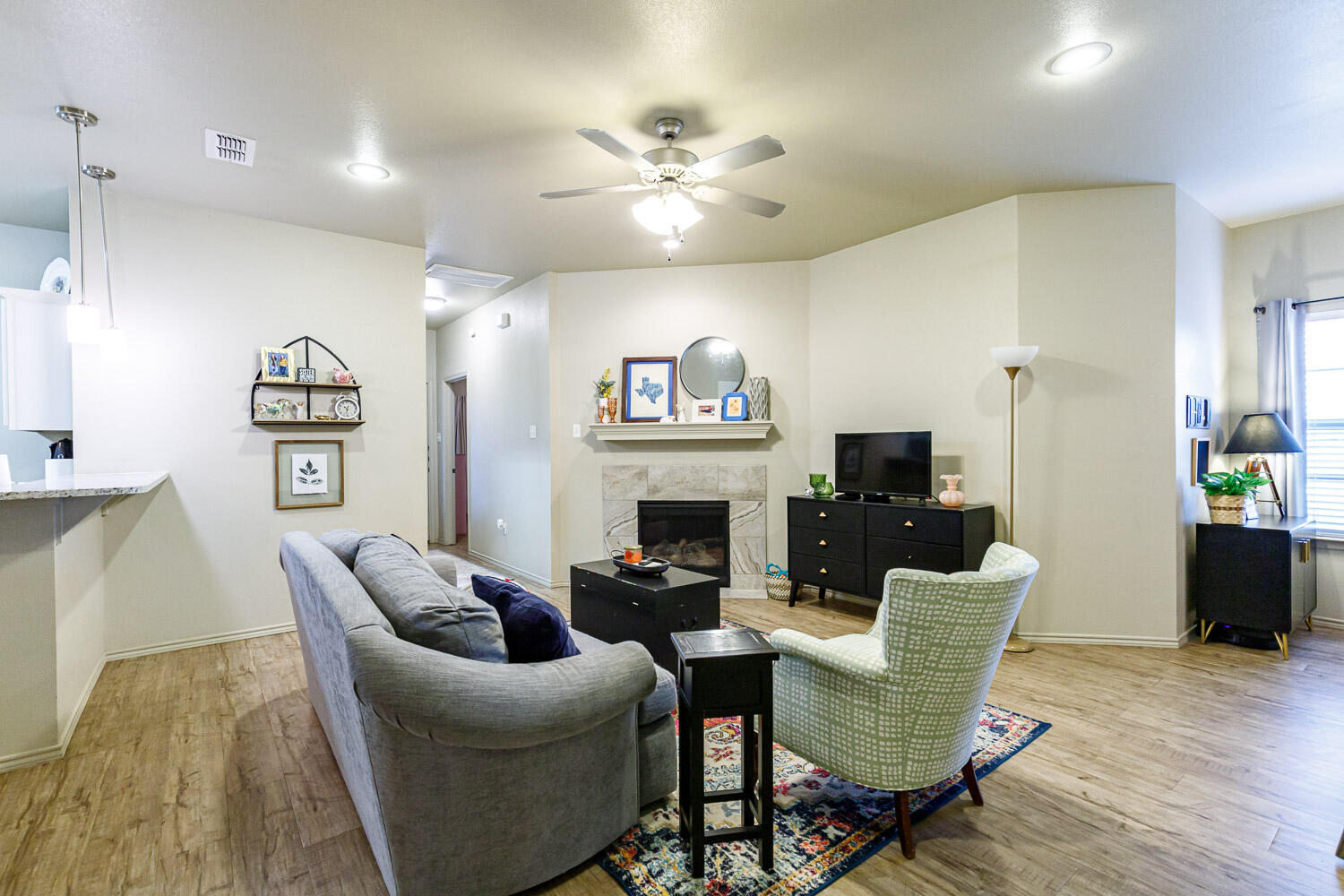 6702 Pontiac Avenue Lubbock, TX 79424 - Photo 12 of 41 a living room with furniture a fireplace and a chandelier