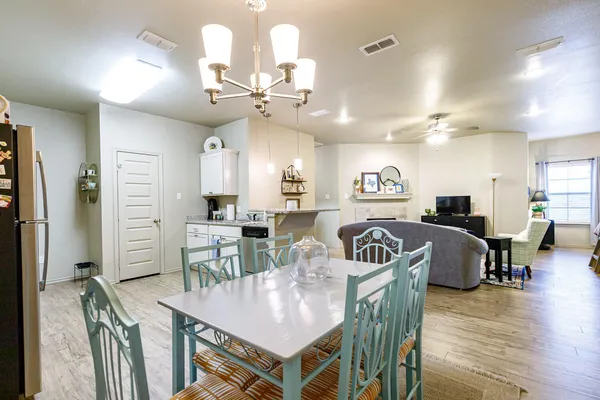 a living room with furniture a flat screen tv and kitchen view