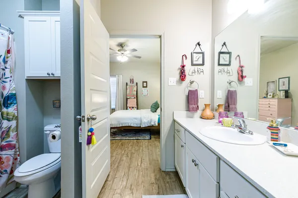 a spacious bathroom with a sink a toilet and shower curtain