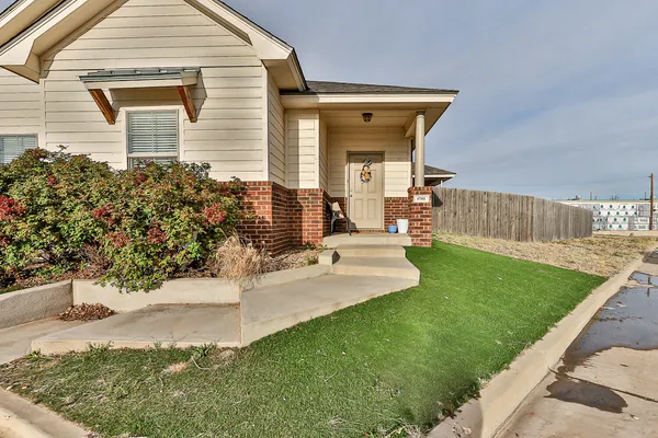 a view of a house with a yard and sitting area