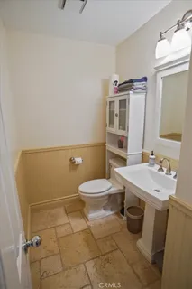 a bathroom with a sink a toilet and mirror
