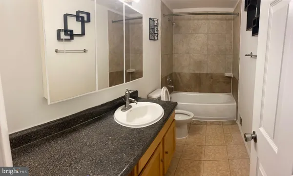 a bathroom with a granite countertop sink toilet and shower