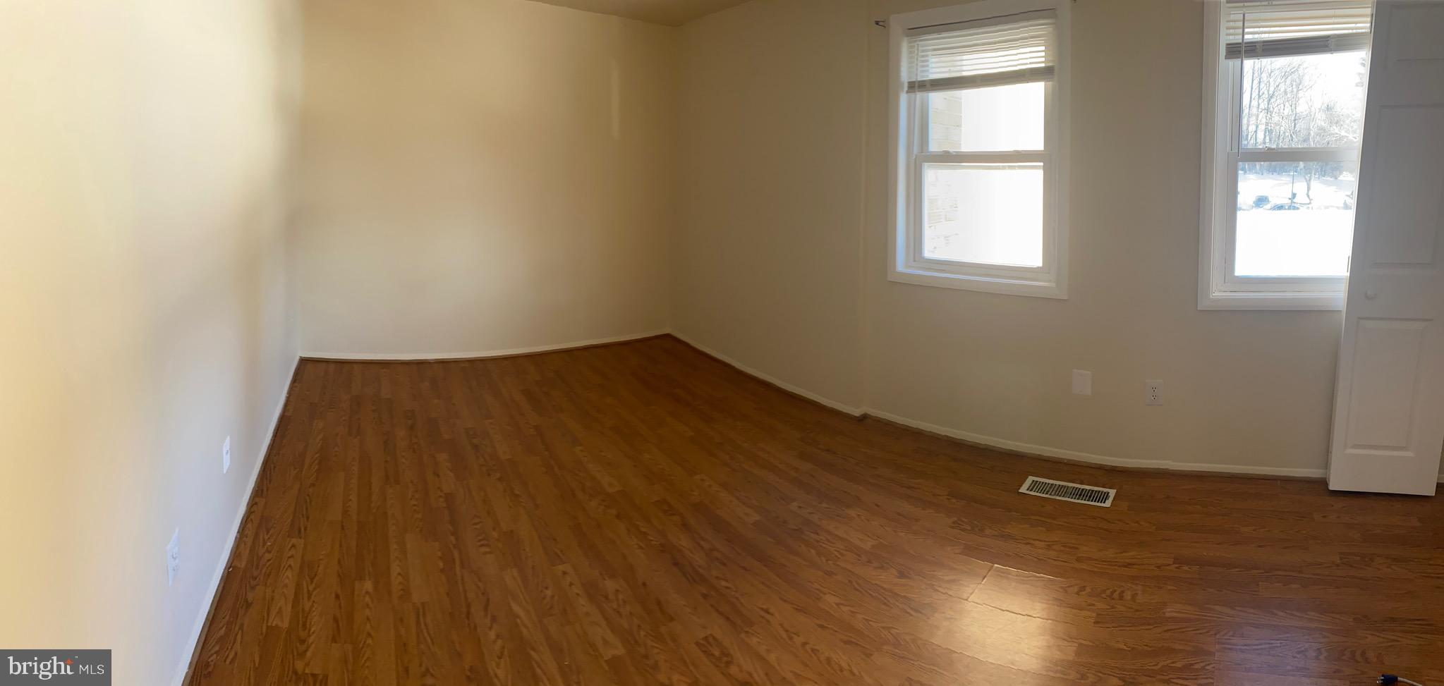 9323 Matador Road Columbia, MD 21045 - Photo 8 of 14 an empty room with wooden floor and windows