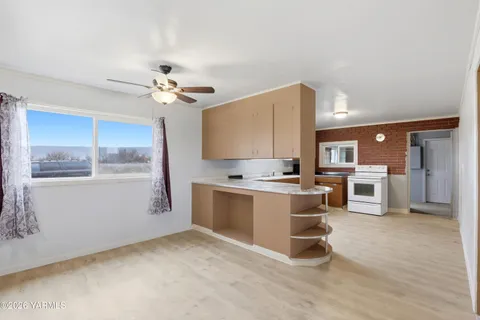 a kitchen with a stove cabinets and wooden floor