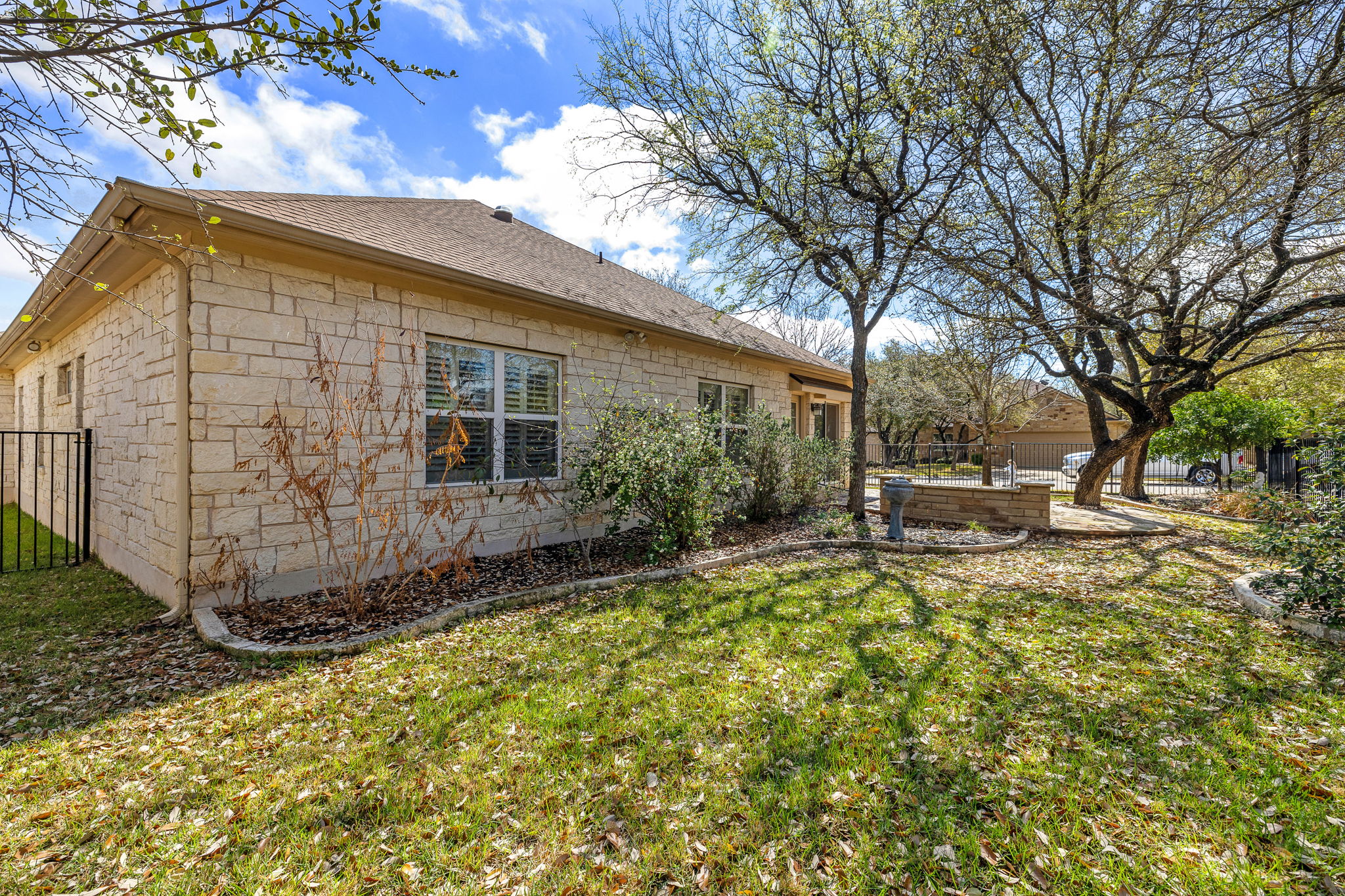 5201 Big Spring Street Georgetown, TX 78633 - Photo 24 of 26 View of side of property with a fenced backyard, stone siding, a shingled roof, and a patio area