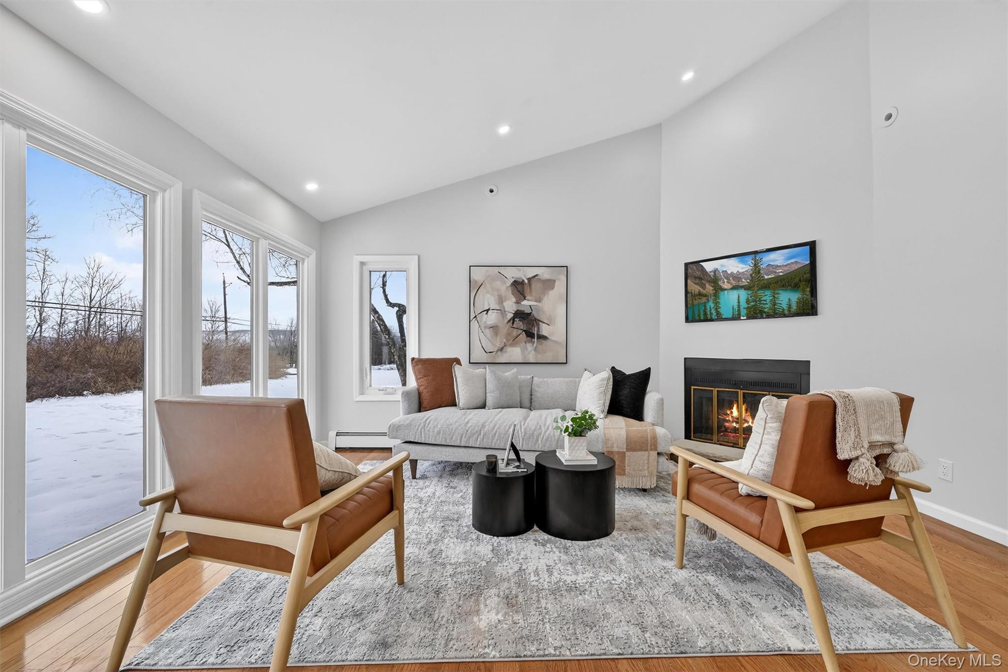 503 Station Road Rock Tavern, NY 12575 - Photo 19 of 47 Living area with vaulted ceiling, light wood-style flooring, a glass covered fireplace, recessed lighting, and a baseboard radiator