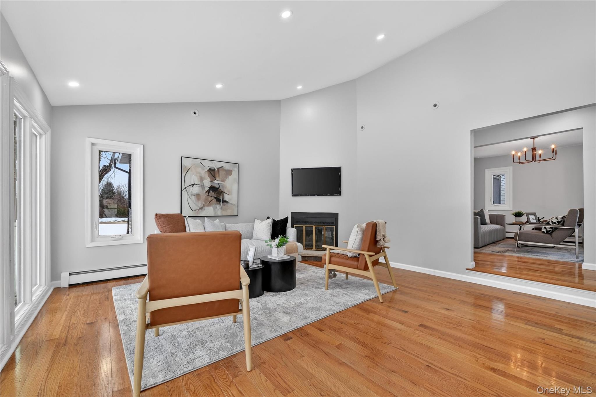 503 Station Road Rock Tavern, NY 12575 - Photo 20 of 47 Living area featuring lofted ceiling, a glass covered fireplace, light wood-type flooring, baseboard heating, and recessed lighting