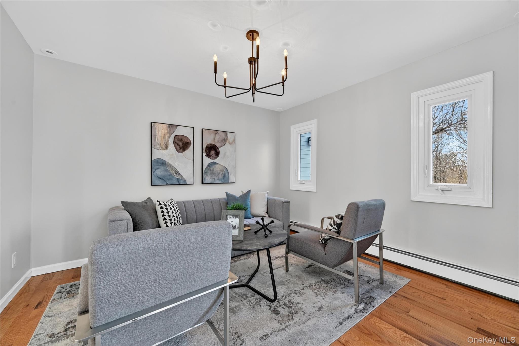 503 Station Road Rock Tavern, NY 12575 - Photo 21 of 47 Living room featuring baseboard heating, light wood finished floors, plenty of natural light, and a chandelier