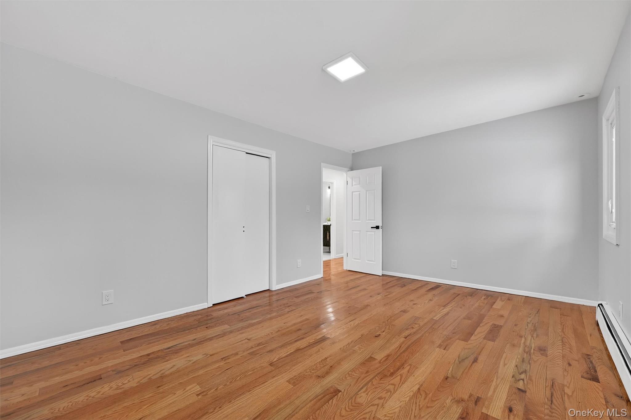 503 Station Road Rock Tavern, NY 12575 - Photo 34 of 47 Unfurnished bedroom with a baseboard radiator, wood finished floors, and a closet