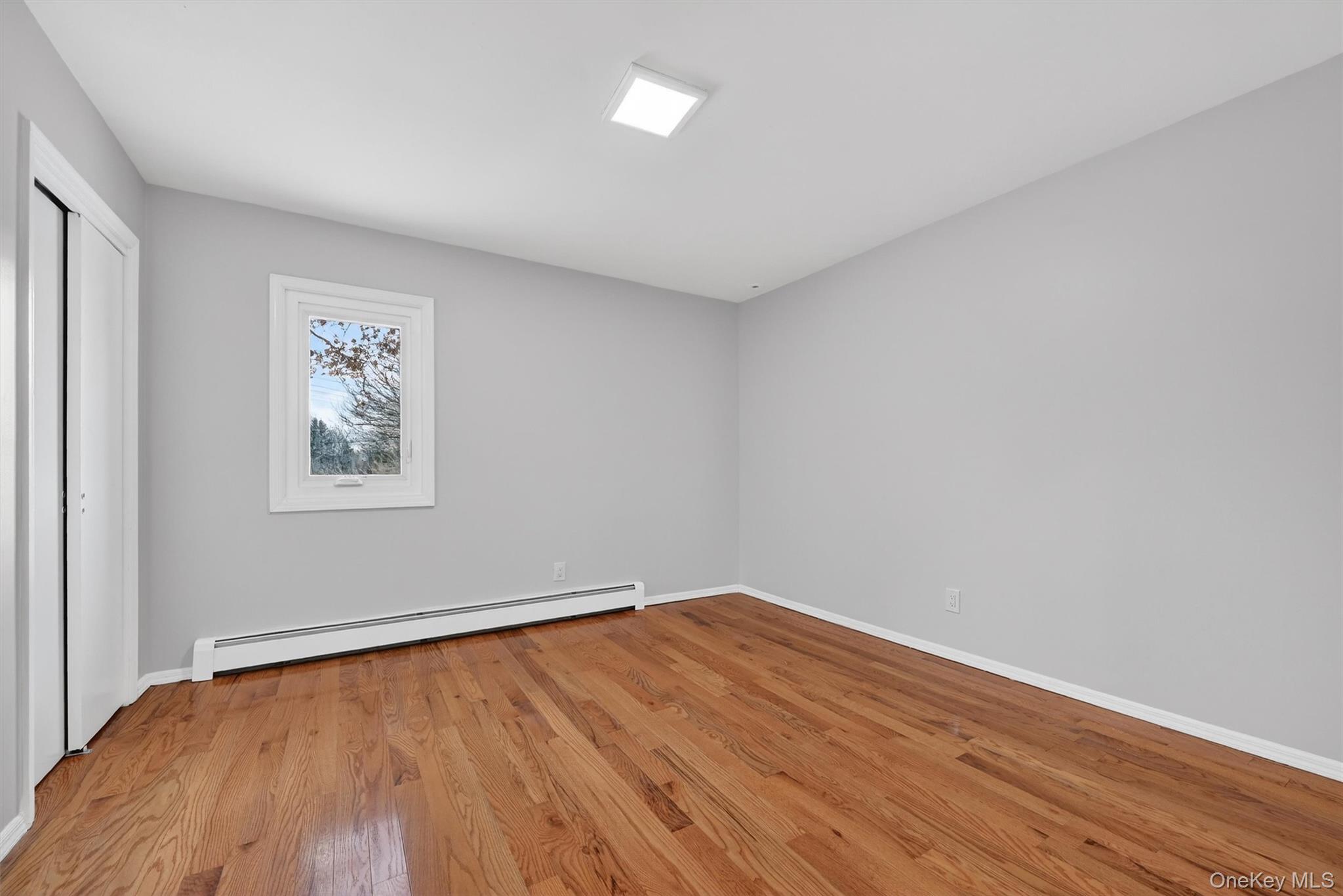 503 Station Road Rock Tavern, NY 12575 - Photo 35 of 47 Unfurnished bedroom with a baseboard radiator, light wood-style floors, and a closet