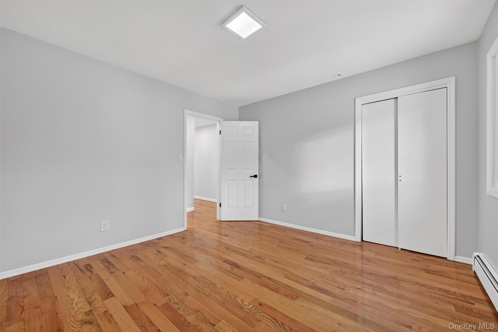 503 Station Road Rock Tavern, NY 12575 - Photo 36 of 47 Unfurnished bedroom with a baseboard heating unit, light wood finished floors, and a closet