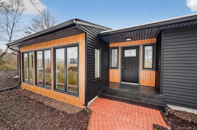 a kitchen with stainless steel appliances granite countertop a stove top oven a sink dishwasher a dining table and chairs with wooden floor