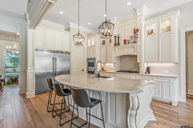 a kitchen with stainless steel appliances granite countertop a kitchen island a stove a table and chairs in it