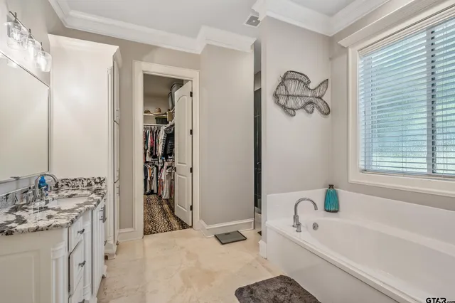 a bathroom with a tub sink and mirror