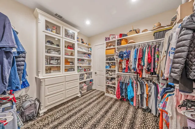 a view of walk in closet with clothes and shoes