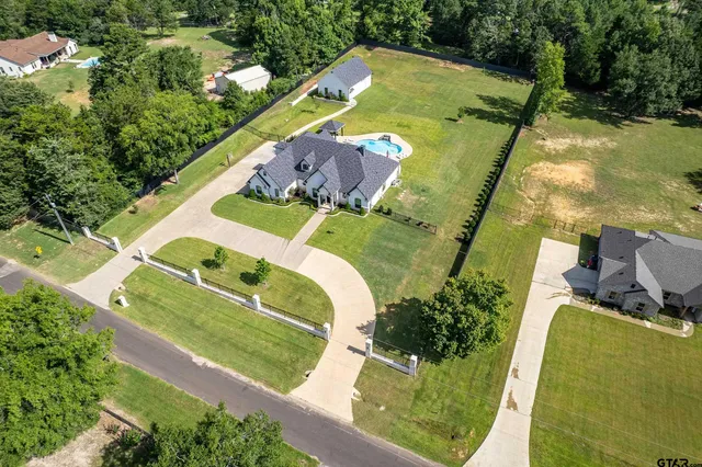 an aerial view of a house with a yard and lake view