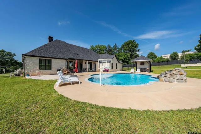 a view of a house with swimming pool and a yard