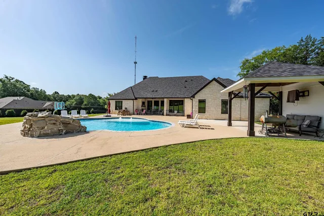 a view of house with outdoor space and swimming pool