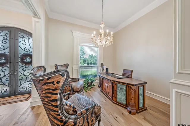 a view of a dining room with furniture a chandelier and wooden floor
